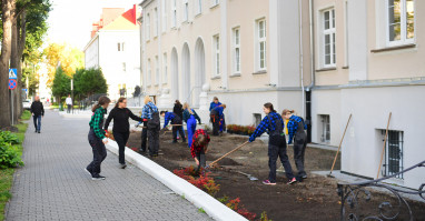 Uczniowie sadzą zieleń przed budynkiem dawnego kina ISKRA